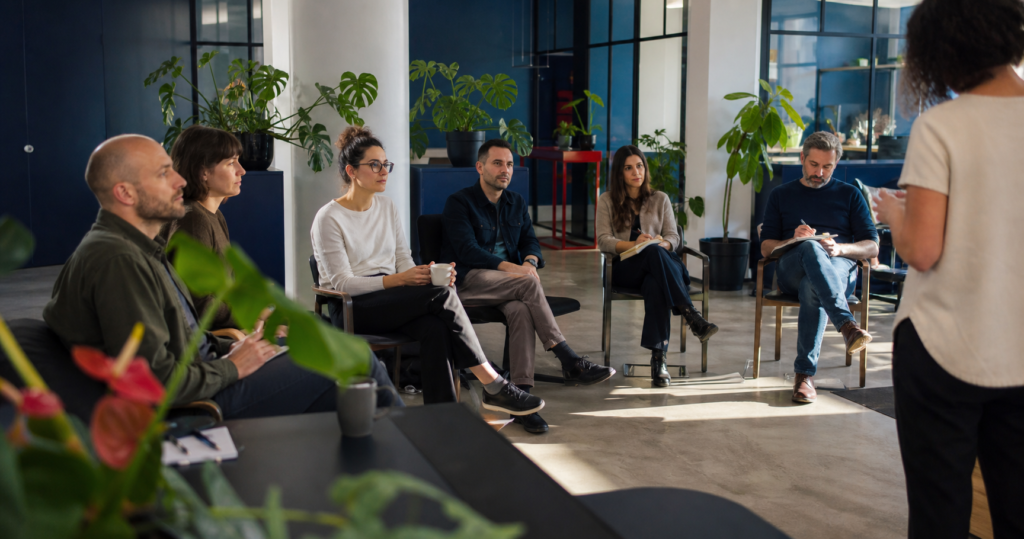 People listening and taking notes during a morning coworking workshop