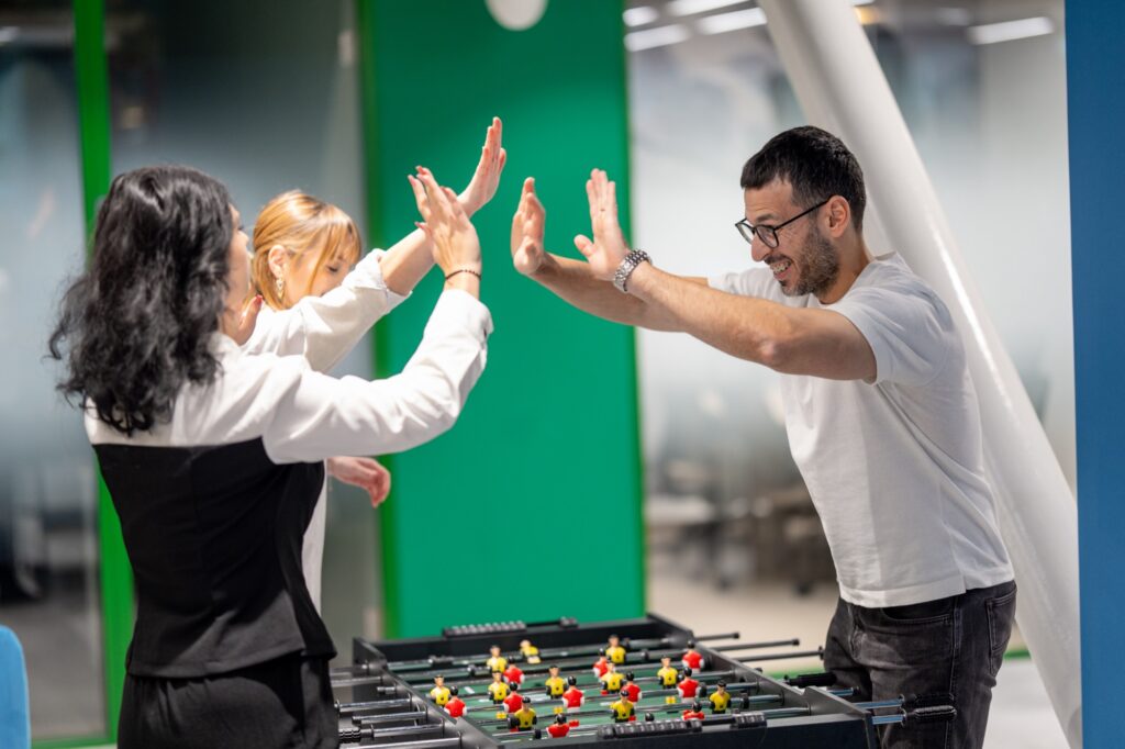 Members celebrating at the foosball table in the Supertree coworking lounge